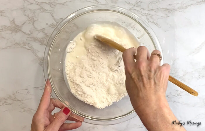 Stir peach cobbler ingredients in glass bowl