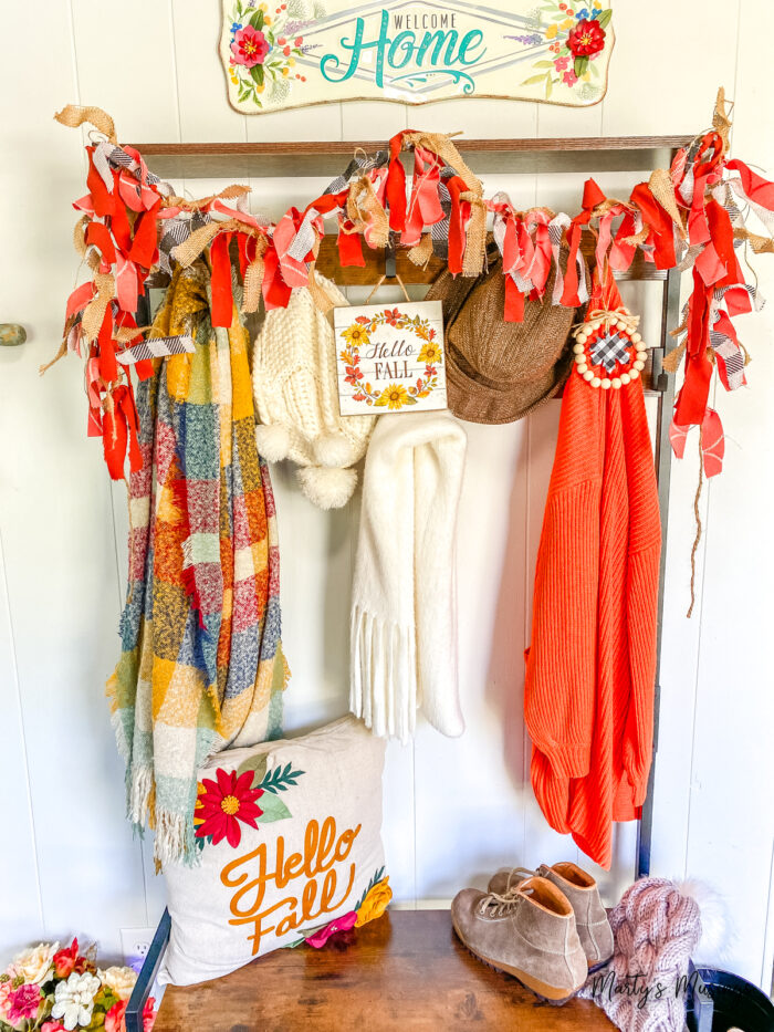 Shelf with fall banner and decor on hooks underneath