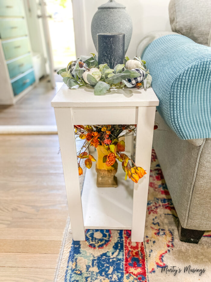 Small white sofa table with silk florals on it