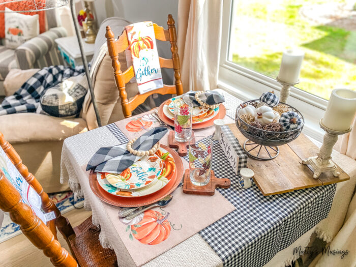 Small table decorated for fall with black and white check and orange and blue table accents