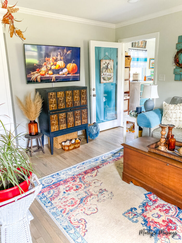 Living room with card catalogue decorated for fall with blues and oranges