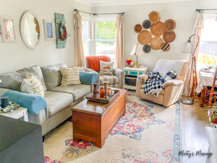 Living room decorated for fall with black and white check and orange and blue accents