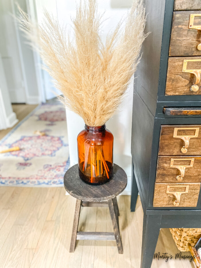 Vintage orange bottle filled with pampas grass