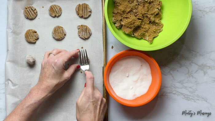 Roll cookie dough in sugar and press flat with fork