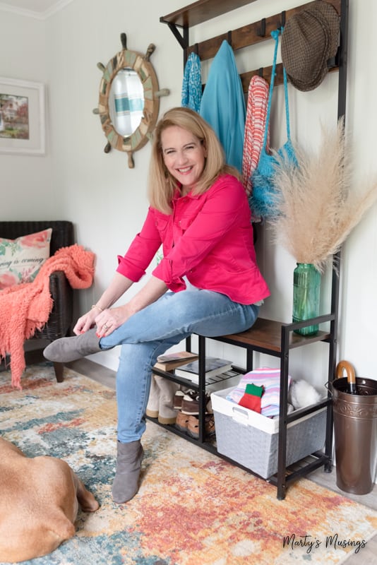 Woman in bright pink jacket sitting on wooden bench