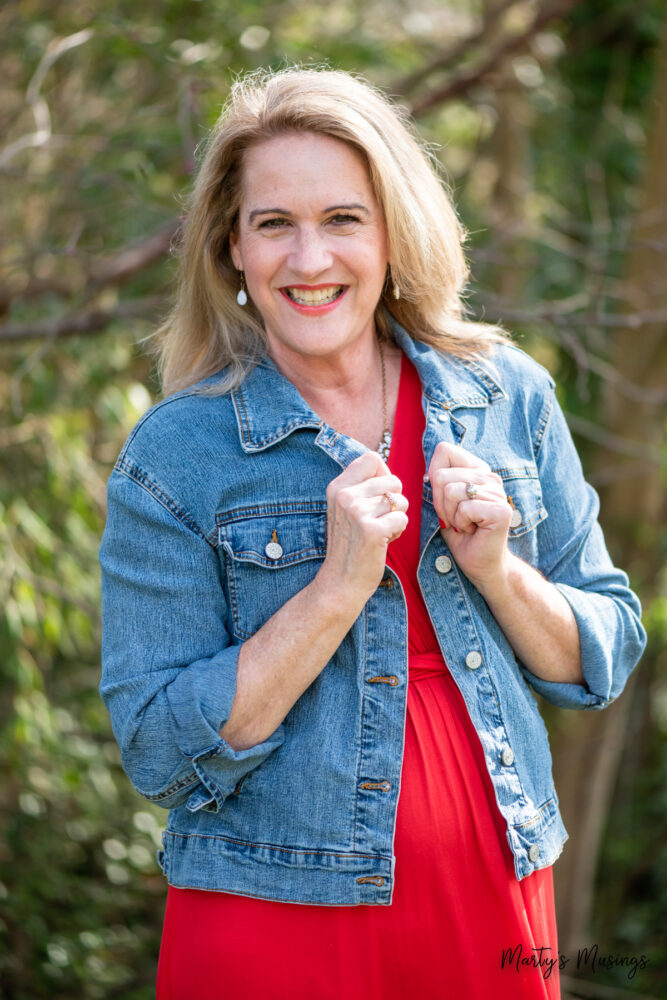 Woman in red dress and blue jean jacket outside