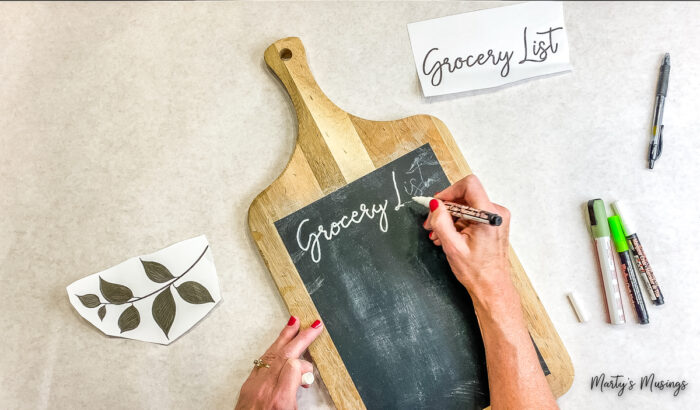 Use chalk markers to add text to chalkboard sign.