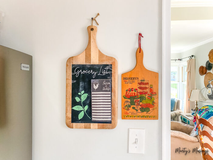 Chalkboard cutting board hanging next to vintage chalkboard in kitchen