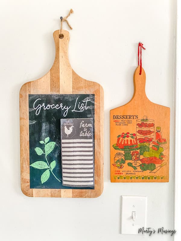 Cutting board chalk sign and vintage cutting board hanging beside each other.