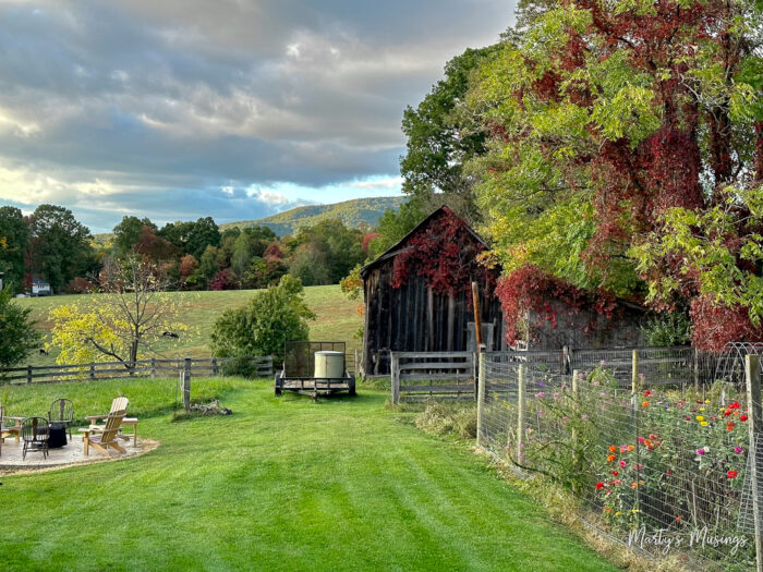 Old barn, garden and view of mountains and clouds