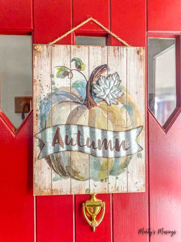 Autumn picture hanging on red front door