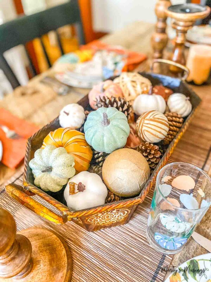 Copper container filled with pumpkins and pinecones as centerpiece