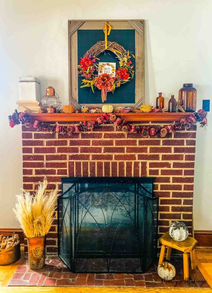 Brick fire place with wooden mantel and fall decorations 