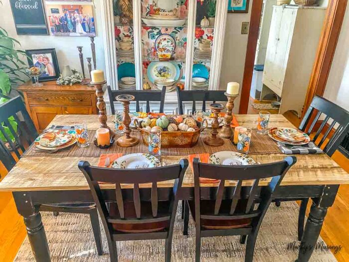 Farmhouse table set with fall dishes an accessories