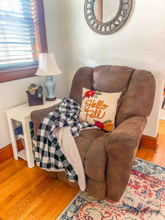 Brown recliner with black and white buffalo plaid throw and fall pillow 